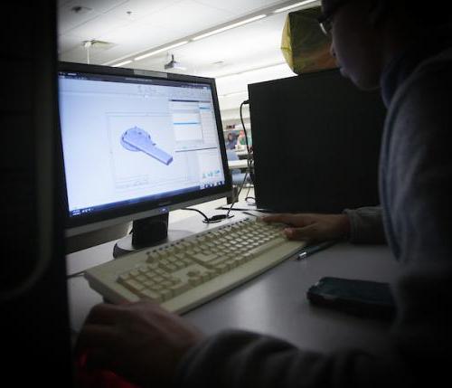 A student creates a component in CAD software while studying machine design.